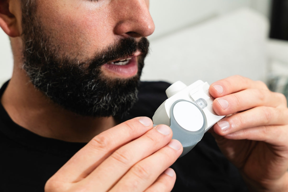 A man with a beard holding an electronic device