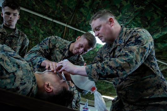 Marines practice medical training on a simulated patient.